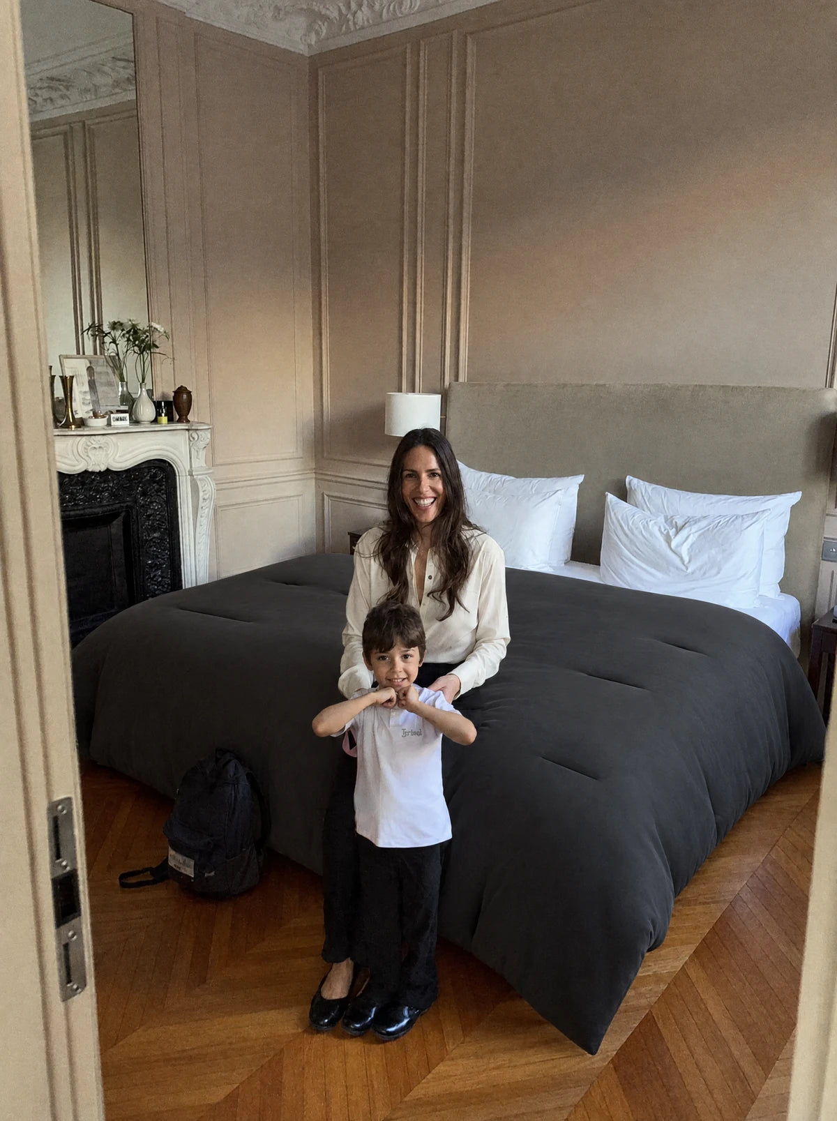 Chambre d'appartement parisien, lit fait avec une couette Whoosh anthracite, une maman et son fils