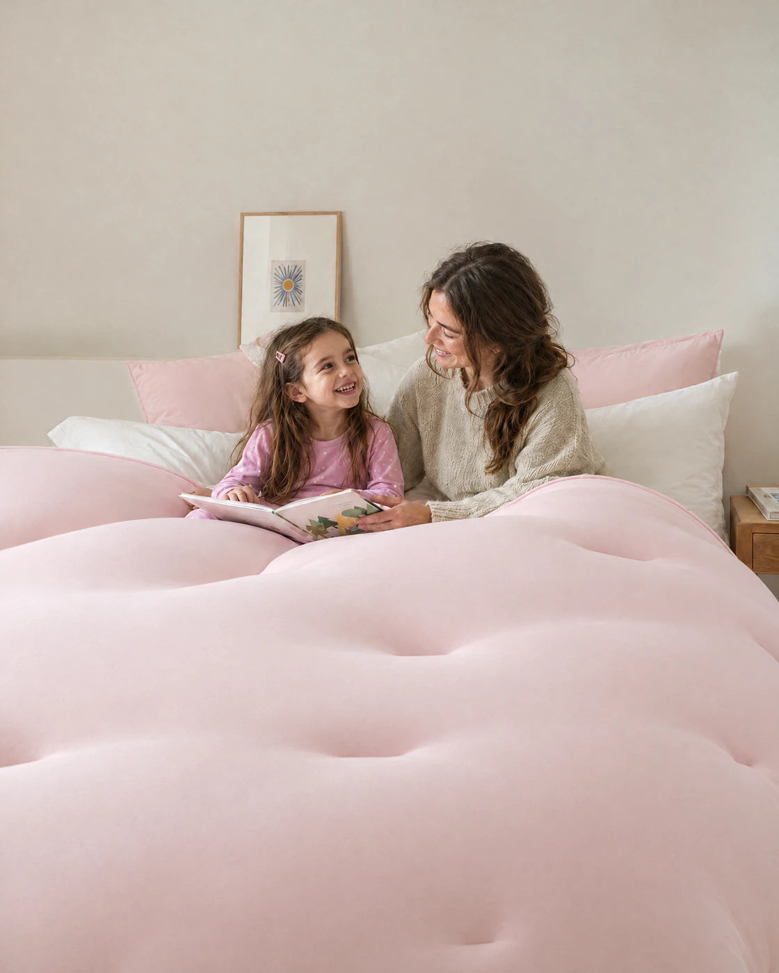 Maman et sa fille qui lisent dans le lit sous la couette Whoosh rose